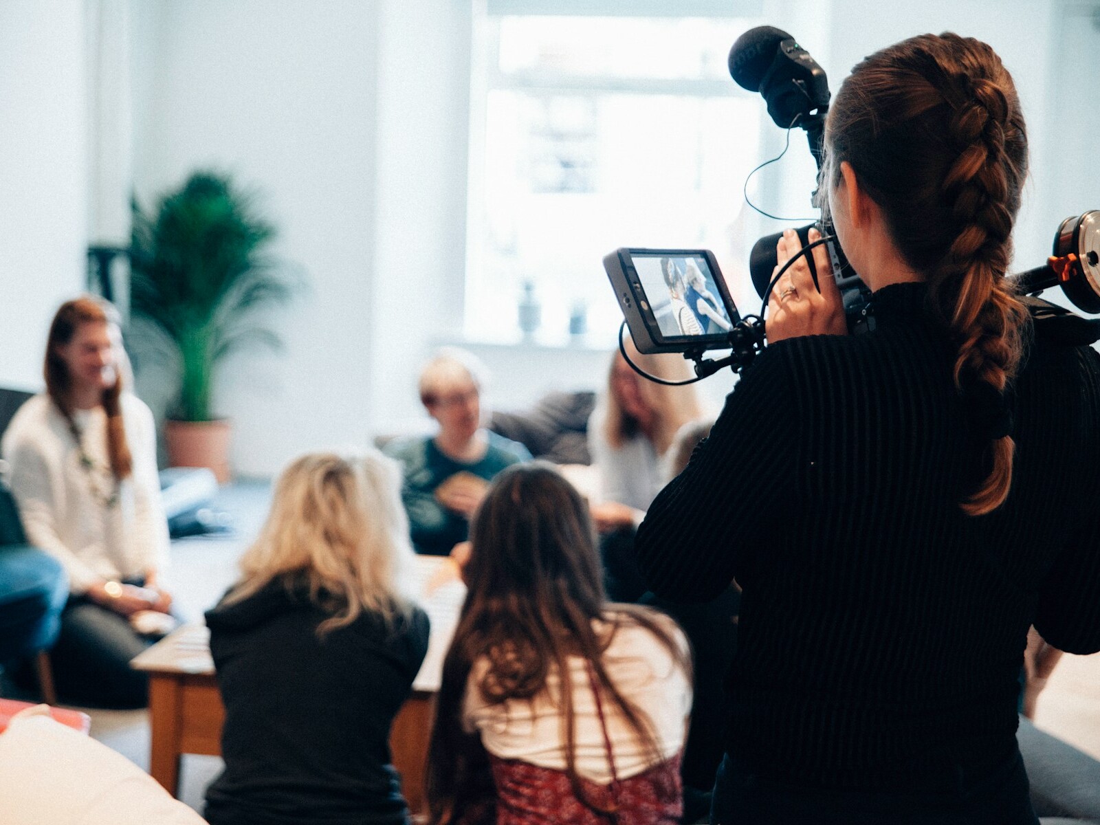 woman holding camera standing near people